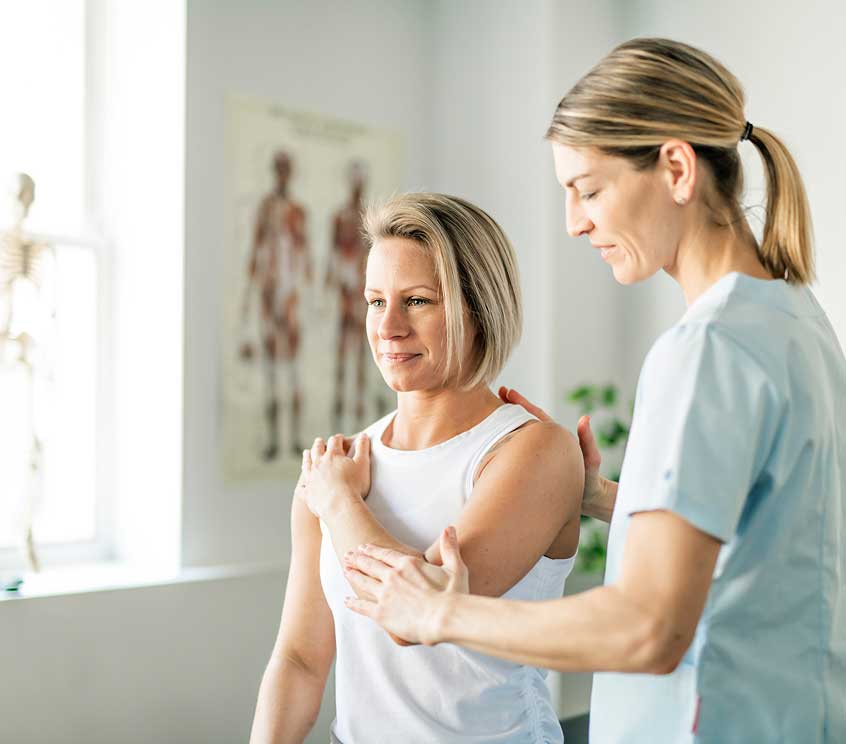 A woman works with a physican therapist